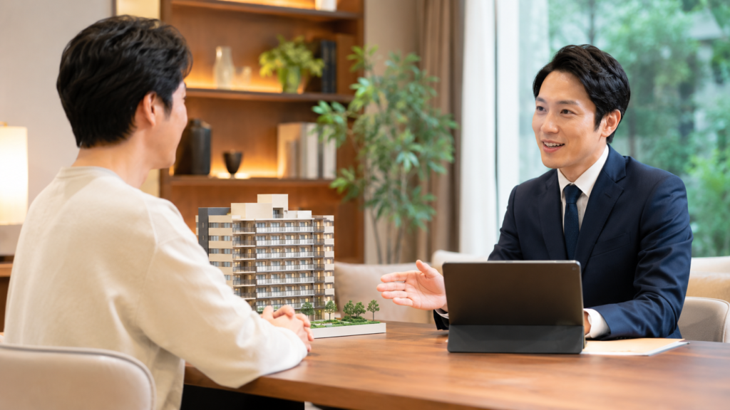 マンション売却の査定内容を不動産会社と比較相談する男性